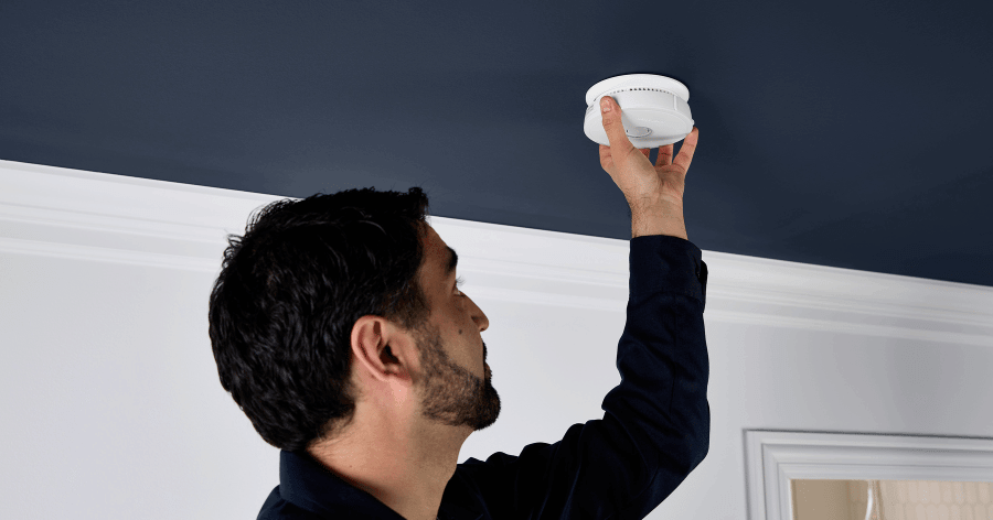 A homeowner is checking the Smoke & CO Alarm 