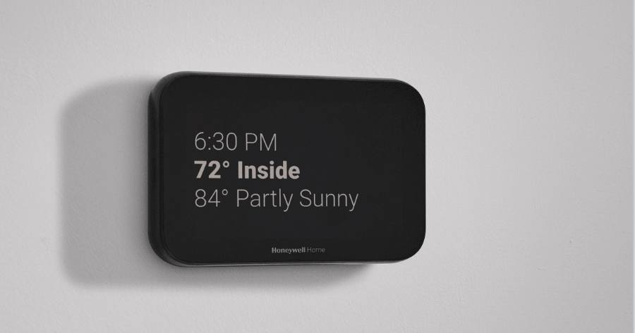 a smart thermostat screen that shows the time , in door and out door temperatures