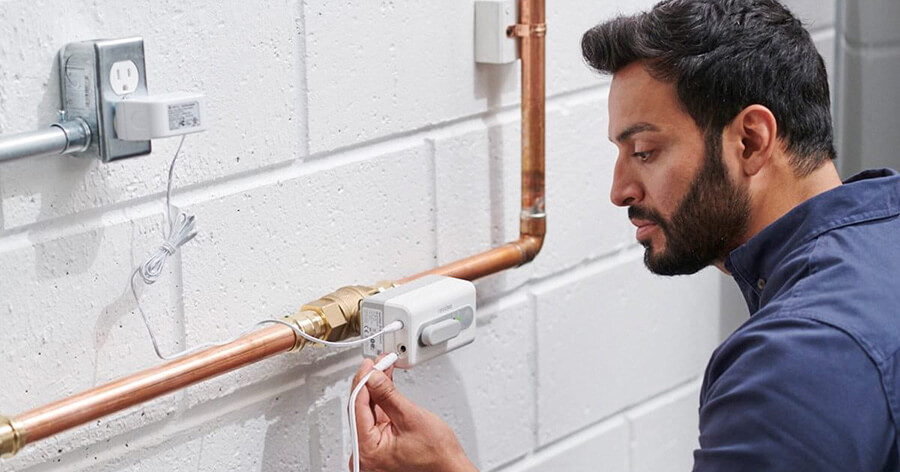 A professional installer is installing a L Series water leak detector.