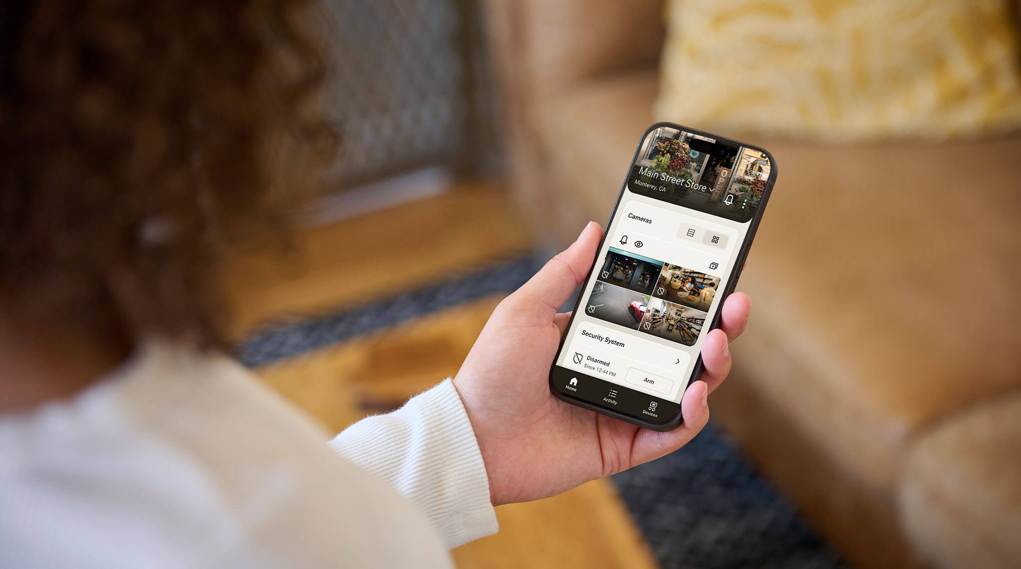 A business owner views security camera feeds from their smartphone app.
