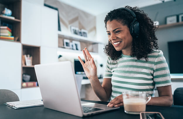 Woman using laptop while wearing headphones