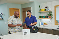 A homeowner and the Installer are checking the app on a device in the kitchen lo res.