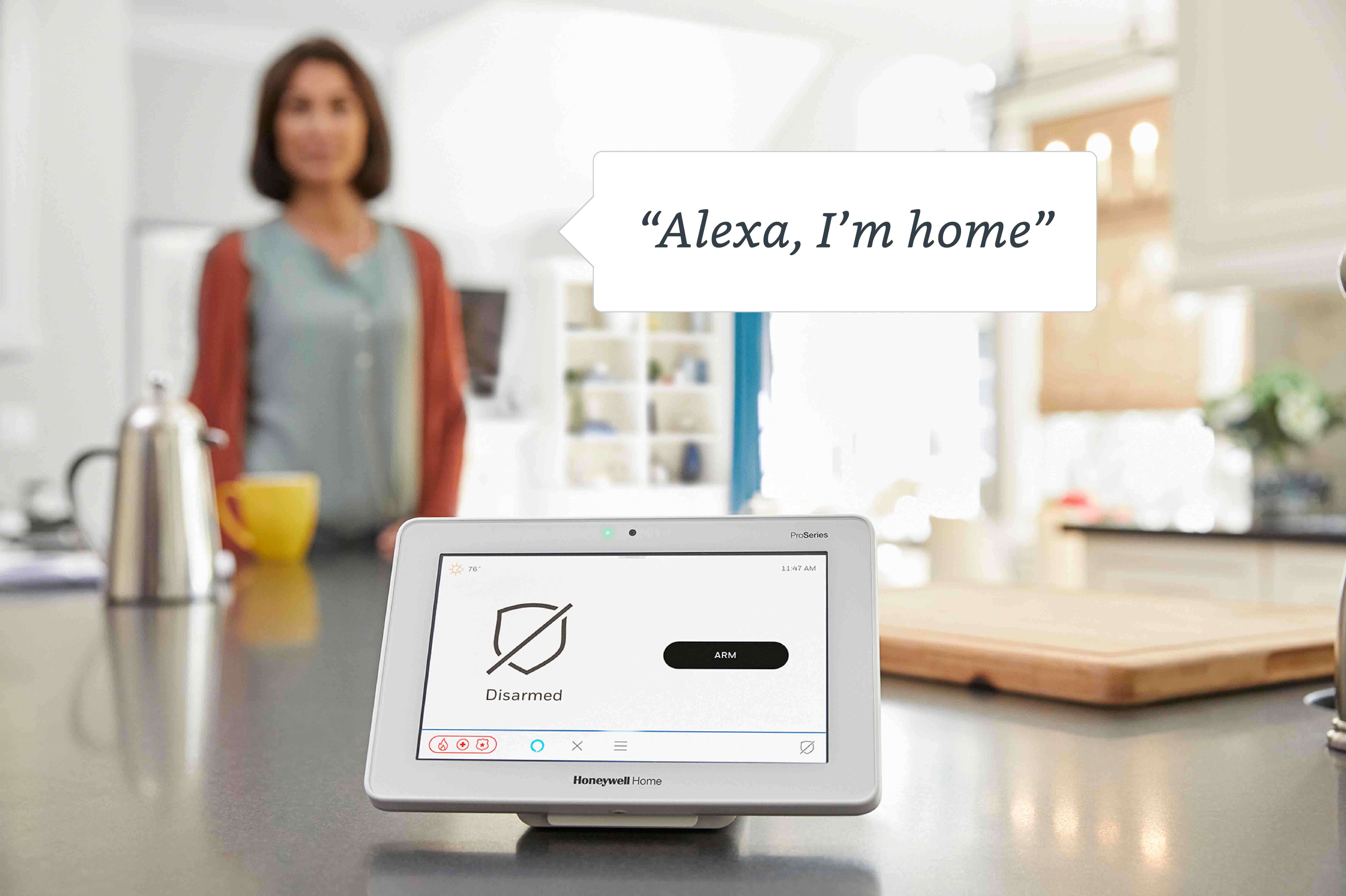 mobile tablet with Alexa on kitchen counter with woman in background.