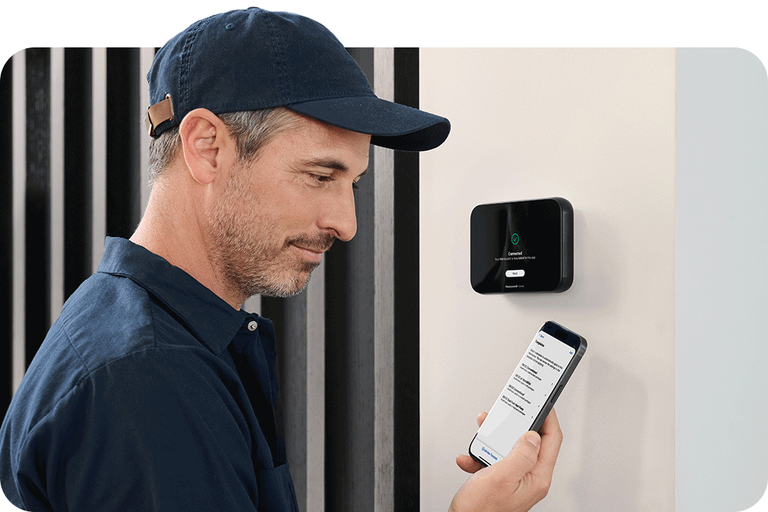 Pro in home holding phone with ElitePro Thermostat
