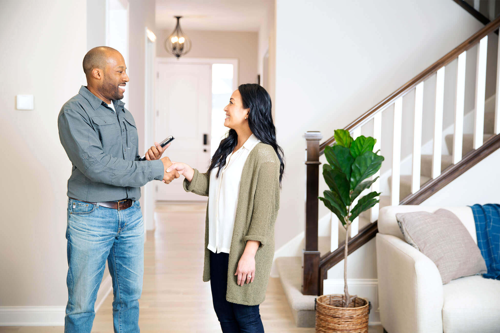 A Resideo pro greets a customer in her home.